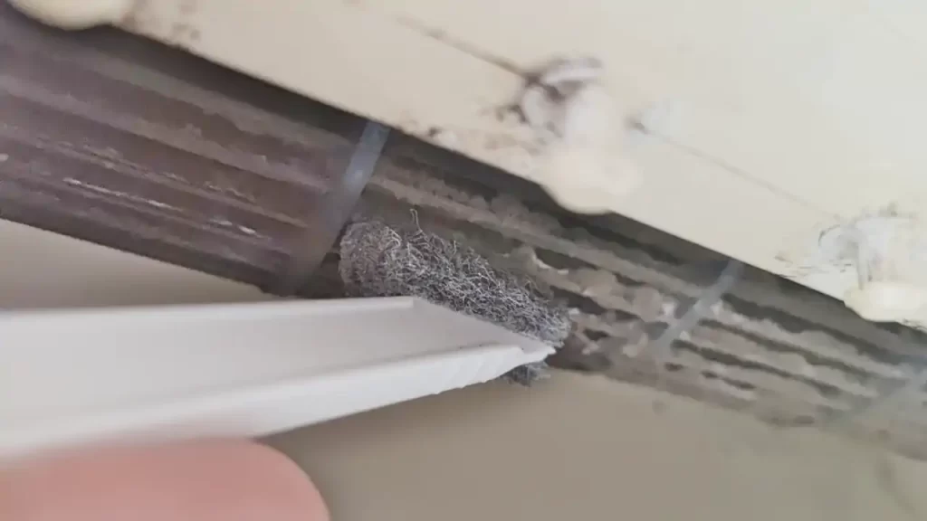 エアコン内部のファンをダイソーのブラシで掃除しているところ