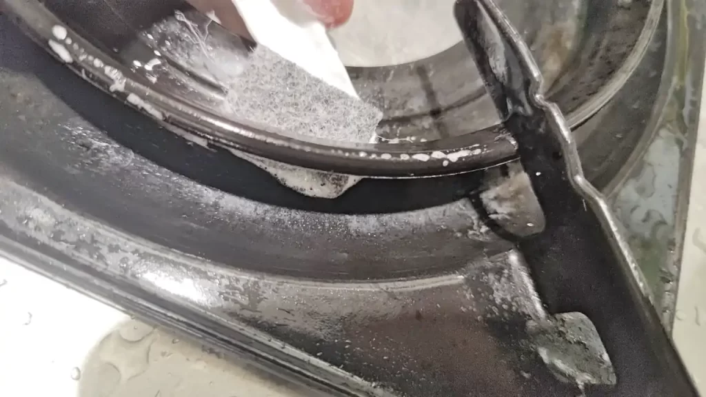 100均ダイソーの「キッチンすき間スティック」で五徳を掃除しているところ